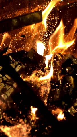 Burning wood is broken with a fire pit with sparks of flame. On a black background. Filmed is slow motion 1000 fps.
