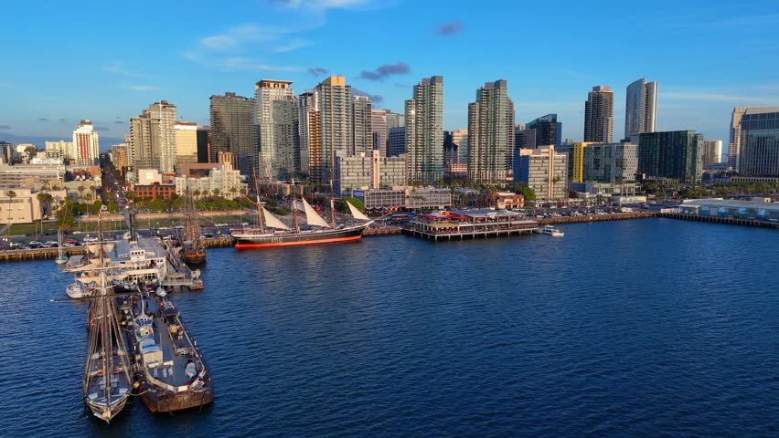 San Diego skyline and harbor at sunset, boats at dock, California city in aerial view on sunny summer evening