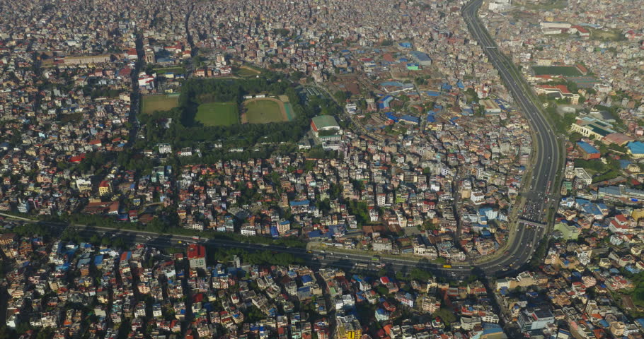 Drone shot of Kathmandu Nepal featuring the Kathmandu Ring Road dense urban neighborhoods and the open green space of Tudikhel surrounded by the expanding Kathmandu Valley cityscape