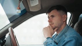 white male driver thoughtful hand on chin inside car, adjusting rearview and checking blind spot, denim jacket visible, dashboard and steering closeup, gentle daylight, preparing to reverse or pull - Powered by Shutterstock - Get 15% off with code: PIKWIZARD15