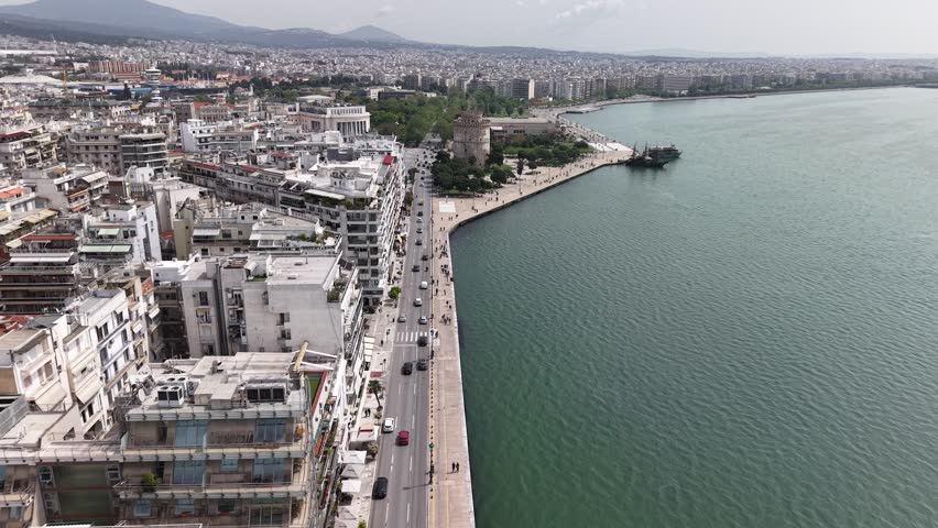 Aerial forward flyover of the White Tower and waterfront in Thessaloniki, Greece