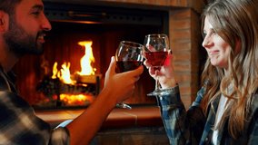 Romantic couple drinking wine by fireplace. Happy young couple toasting with red wine and enjoying a romantic evening by a cozy fireplace - Powered by Shutterstock - Get 15% off with code: PIKWIZARD15