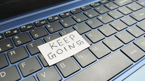 Keep going word Handwritten on white paper placed on top of personal laptop computer keyboard. Work, job and business motivation or inspiration slogan concept. Encouragement to achieve goal or success - Powered by Shutterstock - Get 15% off with code: PIKWIZARD15