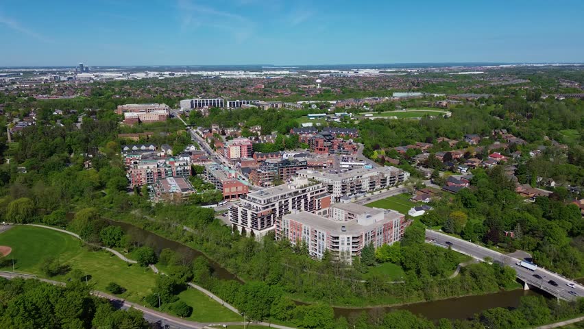 Drone view of residential buildings, condominiums, shopping plaza, and suburban neighborhood in Woodbridge, Vaughan during a sunny spring day with green trees and urban development visible. Vaughan, Canada - May 26, 2026.