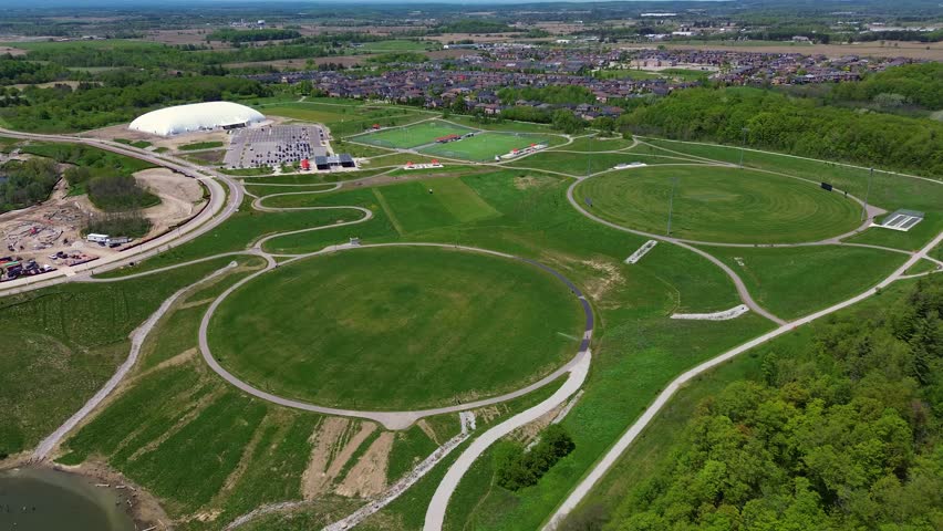 Drone aerial view of North Maple Regional Park in Vaughan Ontario featuring walking trails, green open space, soccer fields, sports facilities, and suburban neighborhoods surrounding the recreation area on a sunny day in Canada. Vaughan, Canada - May 26, 2026.