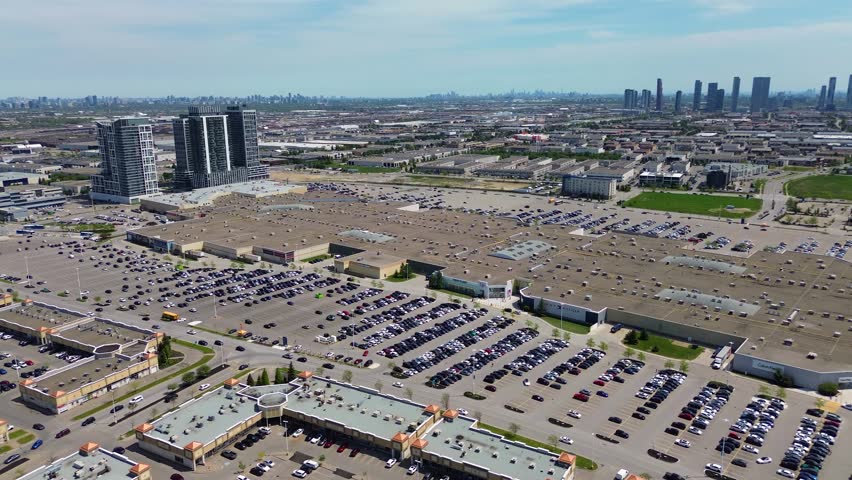 Aerial drone view of Vaughan Mills shopping centre, surrounding retail developments, parking lots, highways, residential towers, and the Greater Toronto Area skyline on a sunny spring day in Ontario Canada. Vaughan, Canada - May 26, 2026.