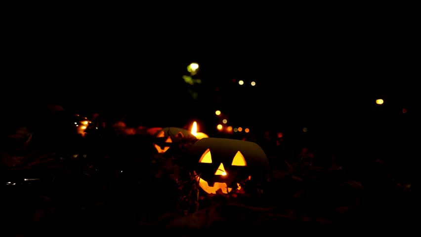 Creepy Halloween night with a spooky pumpkin and misty graveyard. Eerie silhouette of a haunted tree against a dark background. Concept of horror and