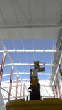 Worker on lifting platform controlling installation of sandwich roof panels inside prefabricated steel warehouse construction site - Powered by Shutterstock - Get 15% off with code: PIKWIZARD15