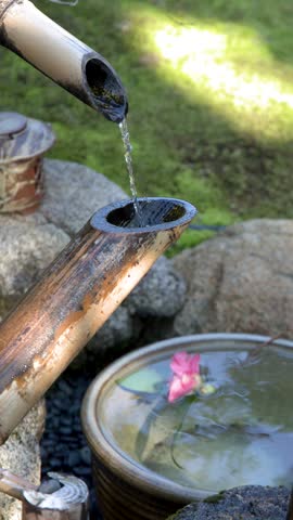 Water flows through a bamboo shishi odoshi fountain into a stone basin in Kanazawa