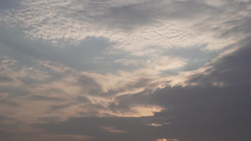 Cloud filled evening sky over a calm lake creating a peaceful natural landscape scene.