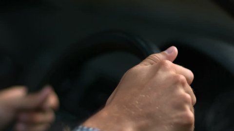 Hands of a man driving a car in slow motion