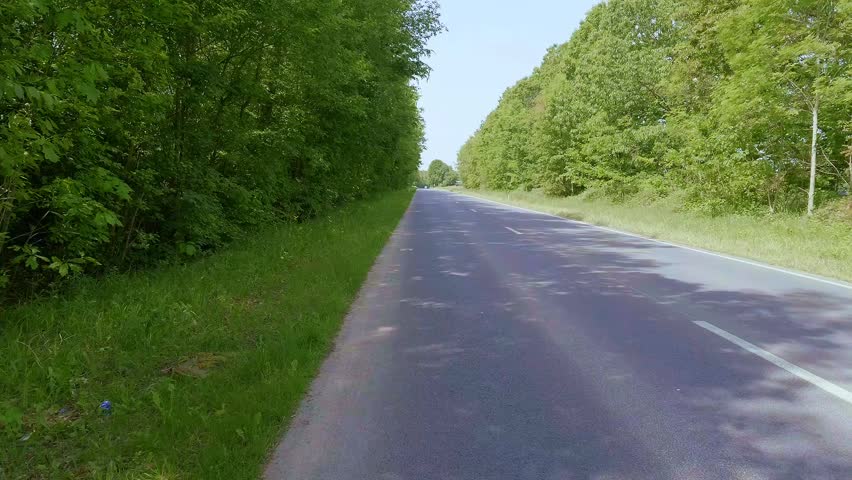 A road beneath a clear blue summer sky.