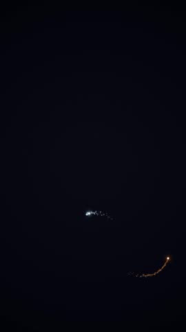 A serene night sky featuring a delicate crescent moon and a bright shooting star streaking across the darkness.