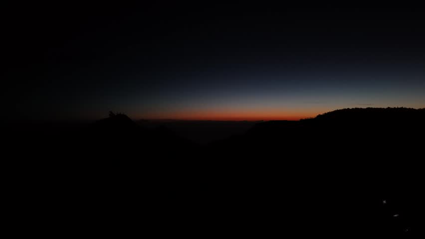 Dramatic Mountain Silhouette at Dawn or Dusk with Colorful Sky Gradient
