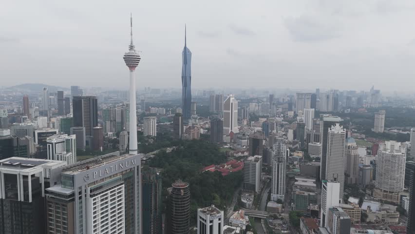 A cityscape with several tall buildings, including the Kuala Lumpur Tower and.