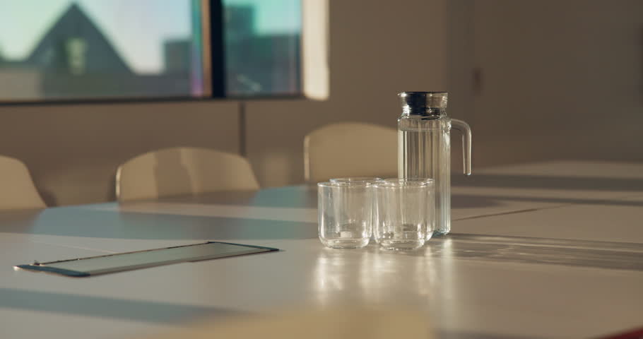 Meeting, glass and water on tablet in empty office for workshop, corporate and boardroom. Planning, conference and furniture with h2o drink on desk of interior room for seminar and workspace