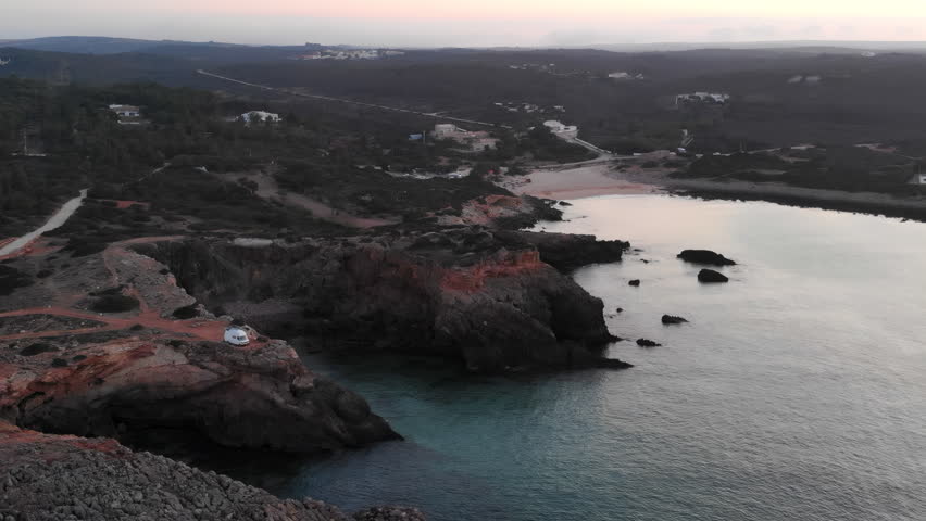 Drone Footage Showcasing Early Morning Light Over Serene Bay Dotted With Stones And Vegetation . Media