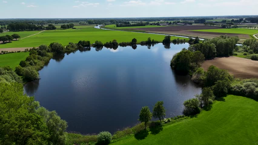 Drone flying over a lake in the green countryside