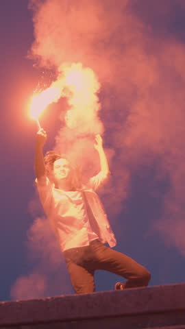 In a vibrant urban setting, a skateboarder in a dynamic pose holds a flare casting a dramatic red glow, symbolizing the energy and rebellious spirit of youth culture.