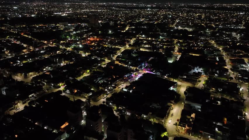 Night aerial view of a police car patrol with emergency lights driving through residential streets