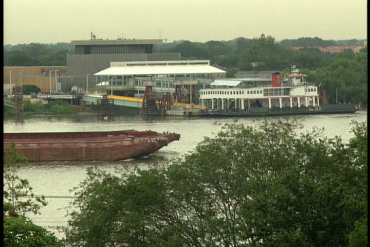 Slow moving barge moves down the Mississippi River in New Orleans.