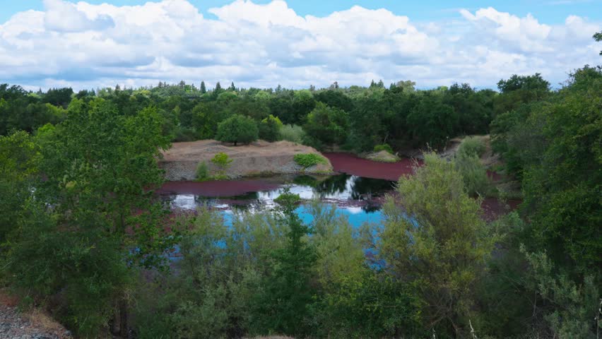 Time lapse over a pond nestled within historic gold mining tailing piles