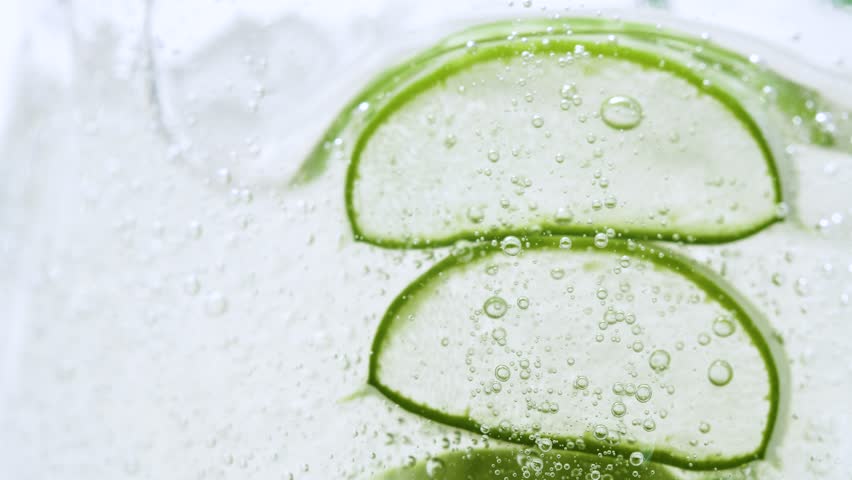 Serum gel texture with aloe vera leaf and bubbles, transparent cream background