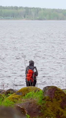 Serene Explorer Observes Tranquil Landscape. Mountain Trekker Studies Silent Lake Surroundings Calmly. Creative