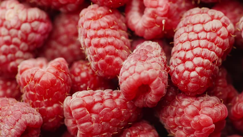 Macro shot of fresh raspberries, rotating berries, fruit texture.