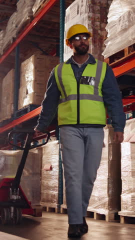 Logistics, walking and man with trolley in warehouse, package export and storage for cargo delivery. Below, transport and worker with inventory for shipment distribution, pallet jack and supply chain