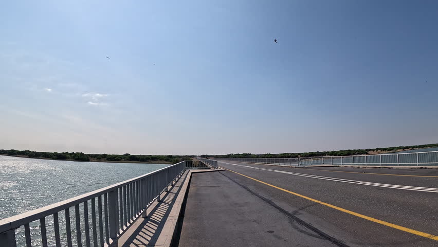 Car crossing the Vaal River bridge beneath clear blue South African sky