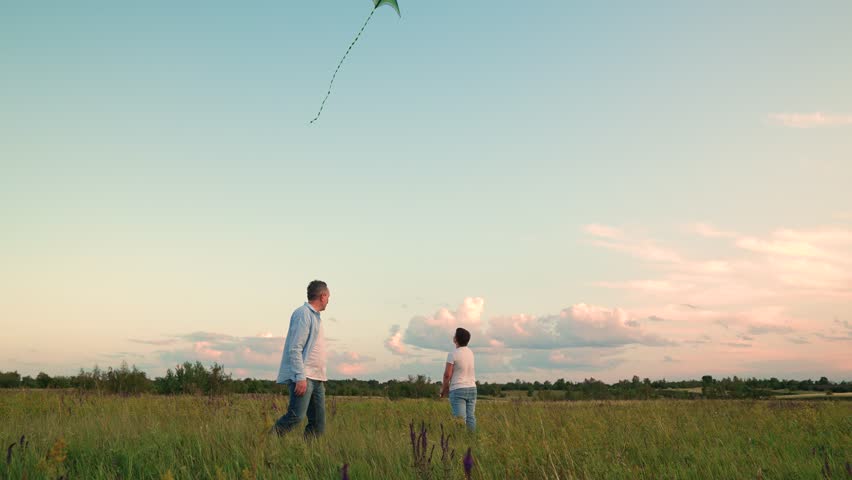 child girl boy father man flying kite, child playing parent outdoors park, wide-angle family sunset activity in meadow, parenthood and childhood joy in scenic meadow, beautiful cloudscape with kite