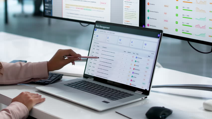 Risk Manager Carefully Analyzes Financial Data On Laptop For Business Continuity Planning.