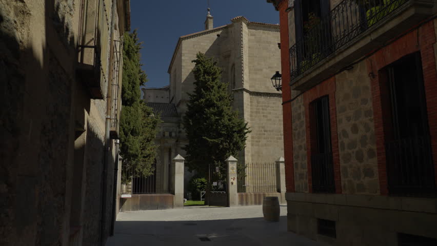 Stone church facade and old street in Avila, Spain, highlighting medieval architecture and serene urban scene
