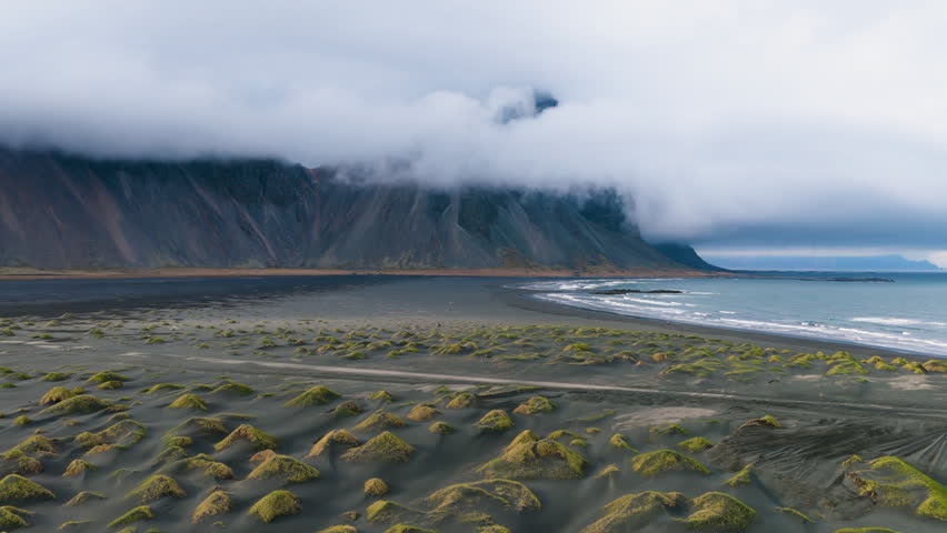 Vestrahorn coastal landscape with mossy rocks Vestrahorn. Hidden Icelandic shore with mist and volcanic formations