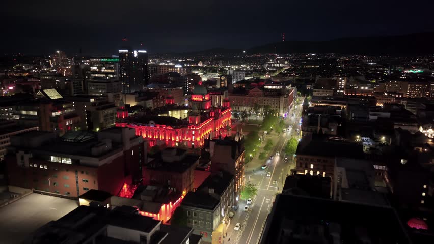 Wide approaching aerial GV of Belfast City Hall in Belfast City Centre at night. Produced in 3840x2160 4K and with Rec709 color.
