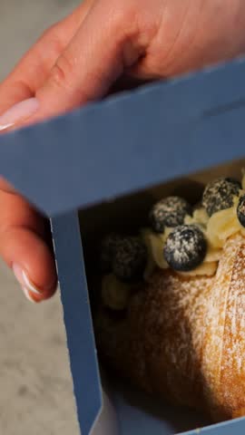 Blueberry pastry delight. Delicious croissant with cream. Sweet blueberry croissant with powdered sugar and flaky layers. Crispy pastry filled with vanilla cream and dusted with powdered sugar