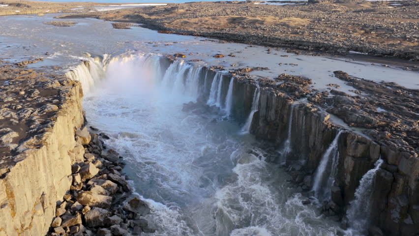 Aerial. Majestic waterfall Selfoss over basalt cliffs. Vast volcanic landscape with rushing river and mist. Iceland
