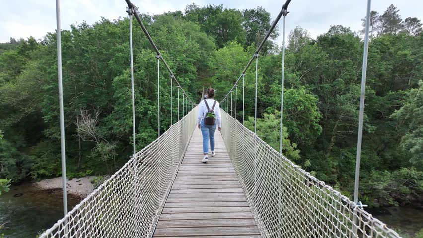 Suspension bridge connecting forest banks over the lerez river in galicia, spain