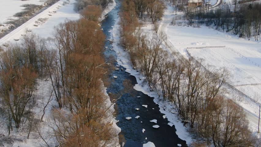 Tree-Lined River in a Snow Covered Landscape