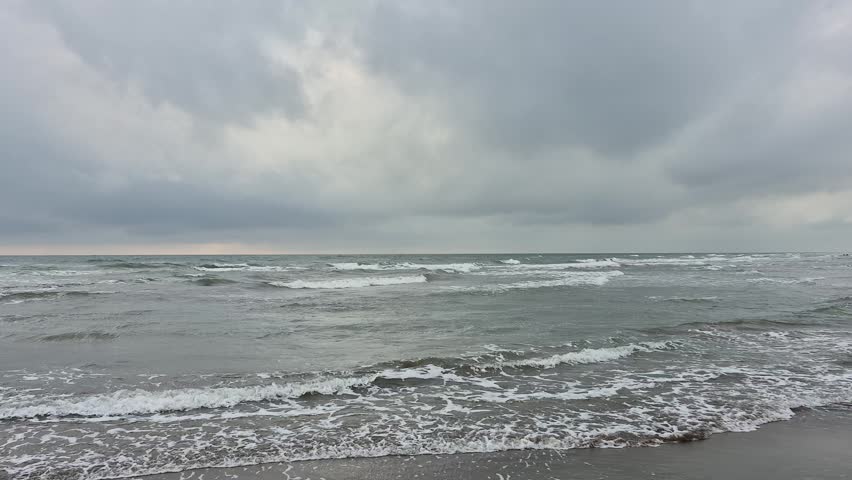 An overcast, windy sky and a choppy sea landscape