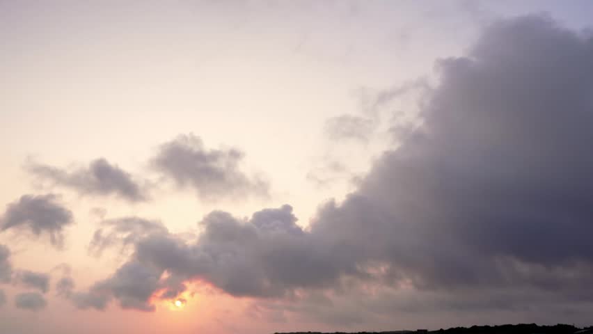 Mysterious sunrise glowing through dramatic moving clouds over Yonaguni Island, Okinawa, Japan