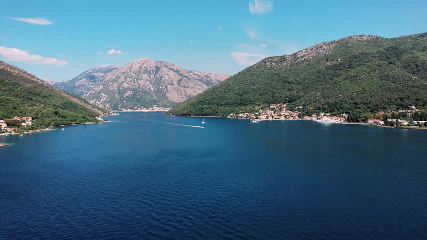 Bright summer day over tranquil blue waters and mountain scenery