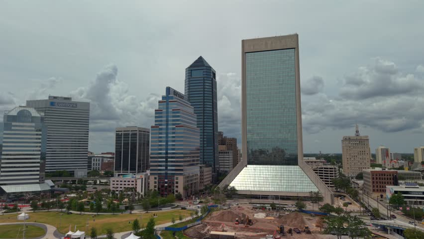 Aerial view of the downtown skyline with modern skyscrapers and urban parks under a cloudy sky Jacksonville, Florida, United States.