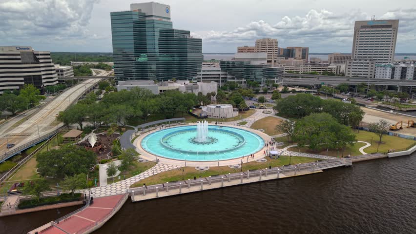 Aerial view of Friendship Fountain with its turquoise water and surrounding park area near the city skyline in Jacksonville, Florida, United States.