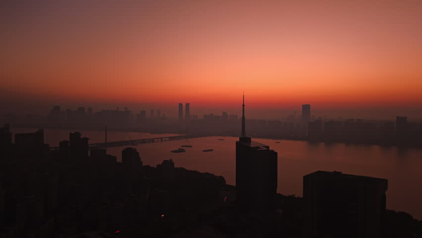 Sunrise in Hangzhou China over urban cityscape with tall buildings and dark silhouettes
