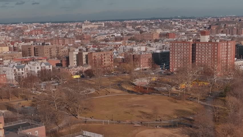 Drone perspective showing a highway merging with coastal roads alongside the rocky shoreline of Brooklyn.