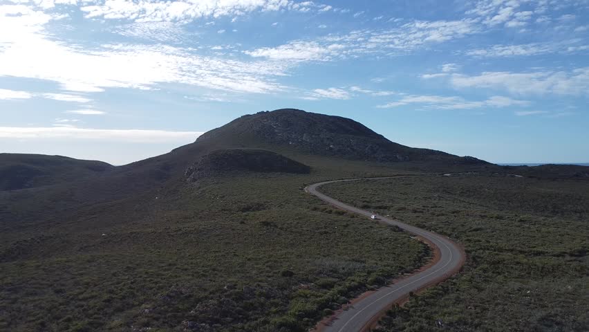 Drone view of a curved mountain road through a remote Western Australian landscape.