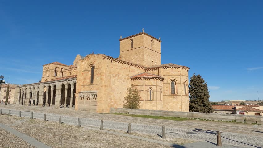 Walking outside the beautiful Romanesque basilica of Saints Vincent, Sabina, and Tristeta in Ávila, Spain