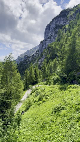 Vertical video shows a granite precipice jutting out in landscape shot of the Austrian Alps in Berchtesgaden. 